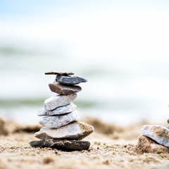 Stones Pyramids on Sand. Sea in the background