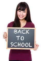 Woman with black board and showing phrase of back to school