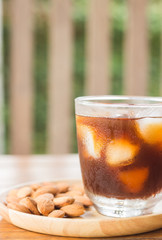 Glass of black iced coffee with almond grain