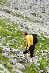 Naklejka na ściany i meble Woman hiking into the mountains