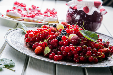 Red currant sponge cake. Plate with Assorted summer berries, raspberries, strawberries, cherries, currants, gooseberries 