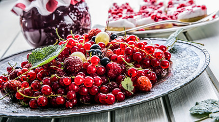 Red currant sponge cake. Plate with Assorted summer berries, raspberries, strawberries, cherries, currants, gooseberries 
