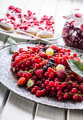 Red currant sponge cake. Plate with Assorted summer berries, raspberries, strawberries, cherries, currants, gooseberries 