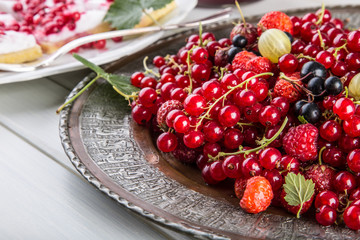Red currant sponge cake. Plate with Assorted summer berries, raspberries, strawberries, cherries, currants, gooseberries 