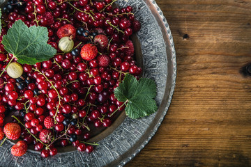 Red currant sponge cake. Plate with Assorted summer berries, raspberries, strawberries, cherries, currants, gooseberries 