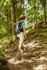 Naklejka na ściany i meble Woman hiking through the forest