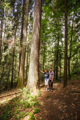 Obraz premium Family hiking through an old forest