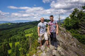 Fototapeta premium Father and son standing on a mountain top