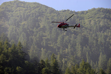 Fototapeta na wymiar helicopter carries cargo in the Alps