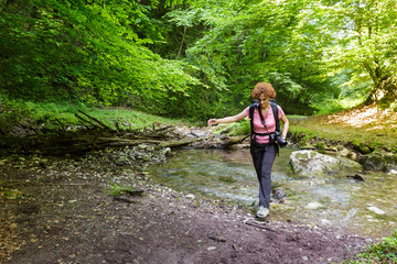 Woman hiker crossing the river