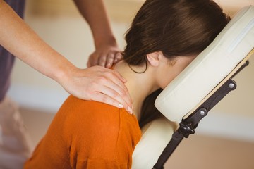 Young woman getting massage in chair - obrazy, fototapety, plakaty
