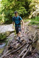 Obraz premium Teenager hiker crossing the river