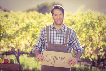 Smiling farmer holding an organic sign