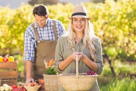 Blonde customer holding a vegetables basket