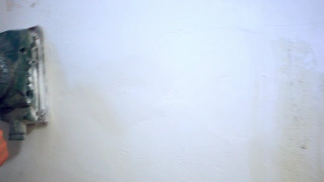 plastering female hand sanding the plaster in white wall