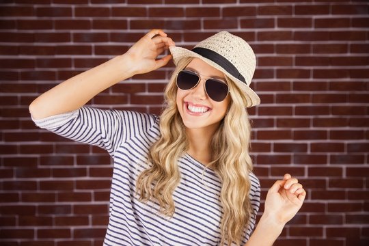 Gorgeous smiling blonde hipster posing with straw hat