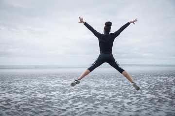 Fit girl leaping on cold day