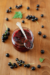 Blackcurrant jam in jar on wooden background