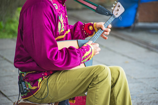 Man playing balalaika on the street. Unrecognizable person.
