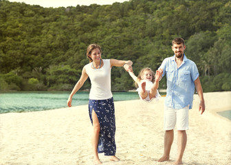 happy family walking on the sea on the beach