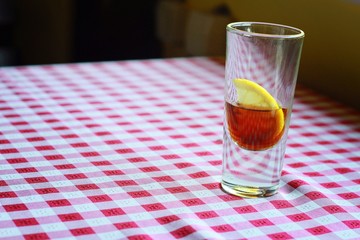 Short drink with lemon on red and white checkered background