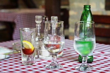 Short drink still and sparkling water at restaurant on red and white checkered tablecloth