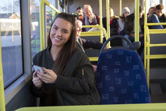 Young woman using her smartphone on the bus