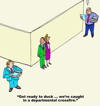 Business cartoon showing two angry businessmen and two businesspeople between them, 'get ready to duck... we're caught in a departmental crossfire'.