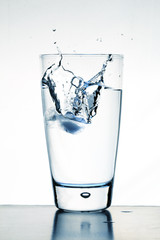 Glass of water on blureflective surface