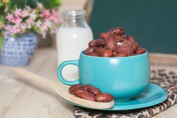 Almonds caramel with milk on table. Selective focus, shallow DOF