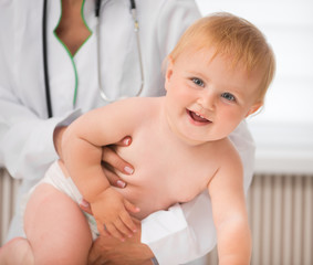 smiling baby on a doctor`s table