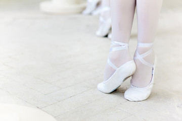 Three little ballerinas dancing. legs in ballet flats close-up
