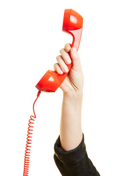 Hand h&auml;lt roten Telefonh&ouml;rer