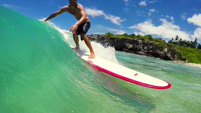Surfer Rides Down the Line in the Curl on a Blue Ocean Wave in Hawaii. Longboard Surfboard.