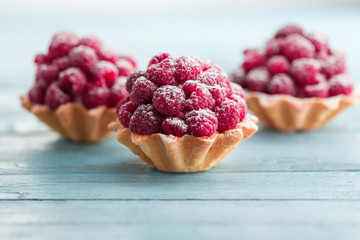Raspberry tartlets with cream filling and dusted with icing sugar
