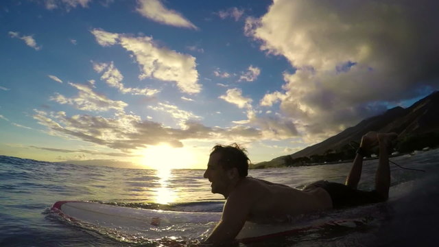 Young Man Paddles out to Surf on a Longboard in Slow Motion at Sunset in Hawaii