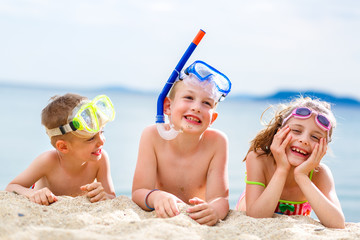 Happy children on the beach with scuba gear