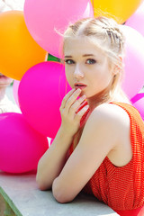 Obraz na płótnie Canvas Closeup portrait of beautiful teenager model posing with bright and colorful balloons
