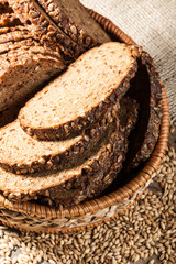 Rye bread with seeds in the basket on a wooden table