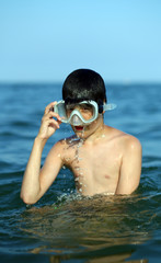 child swims in the sea with the diving mask
