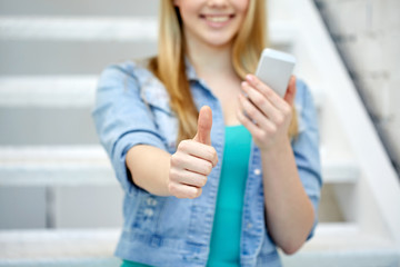 female with smartphone showing thumbs up