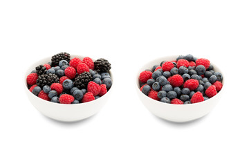 Two bowls with blueberries and raspberries and blackberries. © tomalv