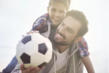 Gordijnen Father teaches son how to play football © gpointstudio