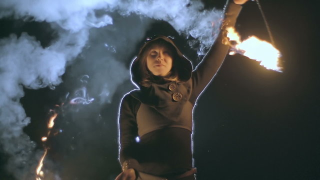 Close up of fire juggler spinning burning staffs
