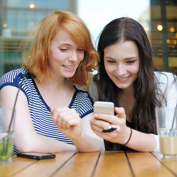Two young girls using smart phone