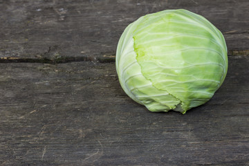 Green cabbage on an old wood rustic background