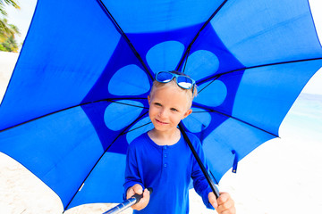 Selfie of happy little boy with umbrella on rainy day
