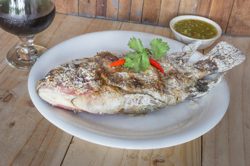 fish grilled with salt on wood background,Thai food