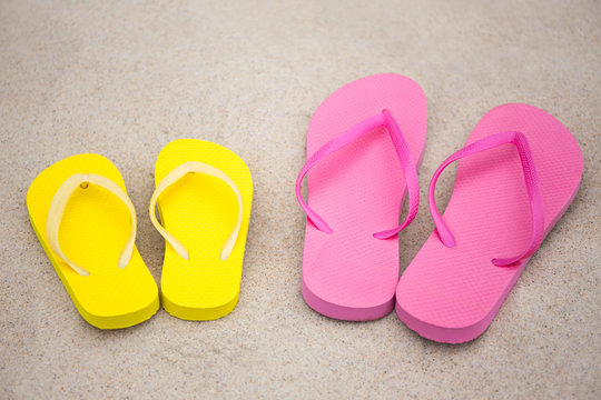 colorful flip flops on sandy beach