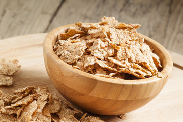 Whole grain wheat cereal for breakfast in a wooden bowl, selecti